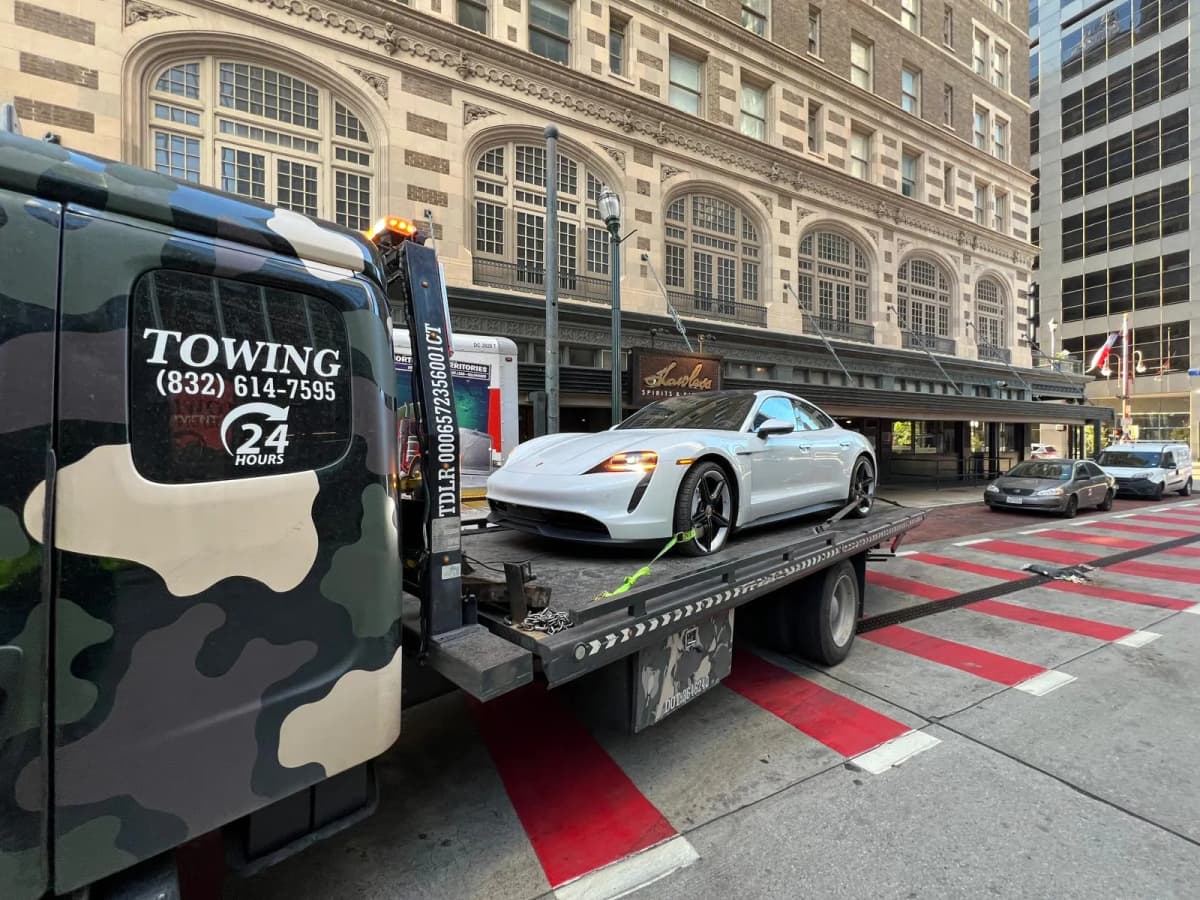 Porsche Taycan EV Towing - Downtown Houston TX Porsche Taycan electric car on flatbed tow truck in downtown Houston TX