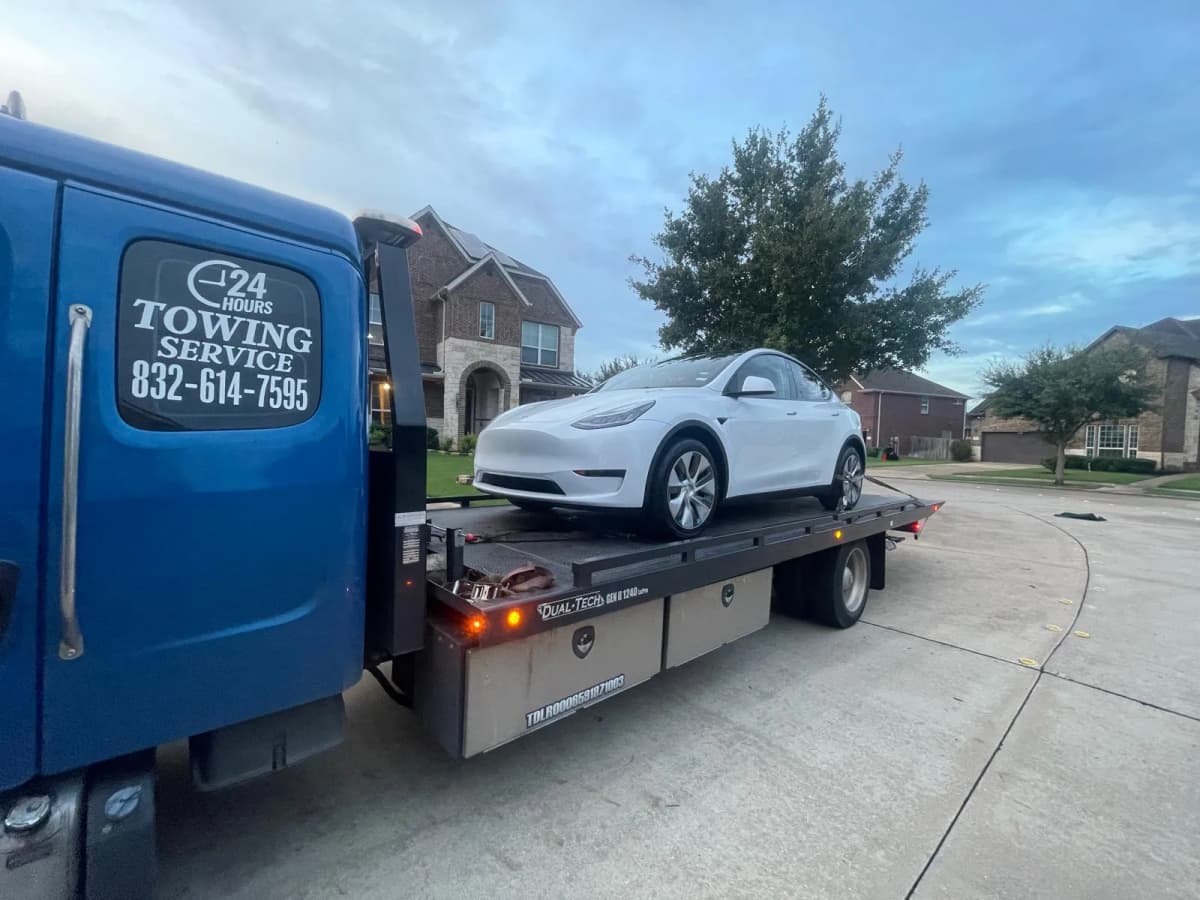 Tesla Model 3 Flatbed Towing - Houston TX Tesla Model 3 safely loaded on flatbed tow truck in Houston TX residential neighborhood