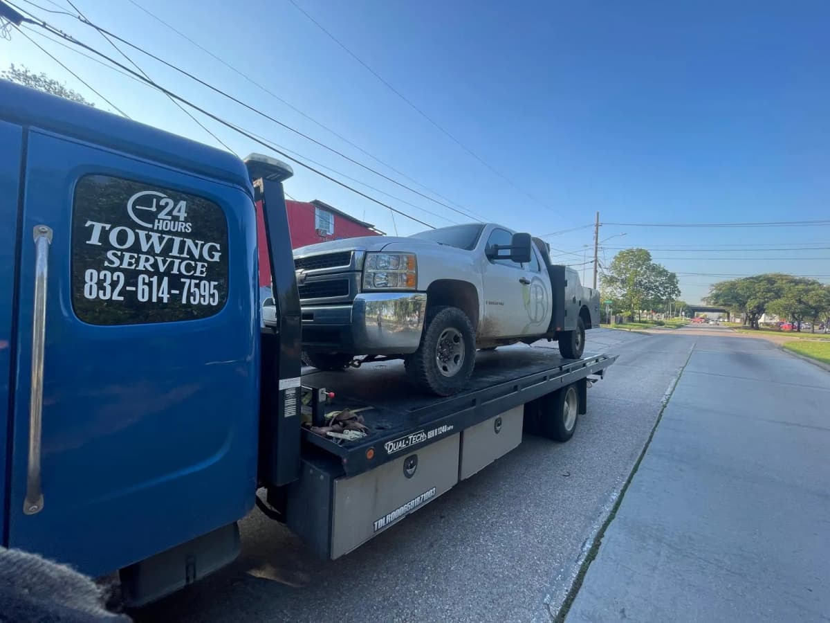 Chevy Silverado Towing - Houston TX Silver Chevrolet Silverado on flatbed tow truck in Houston TX