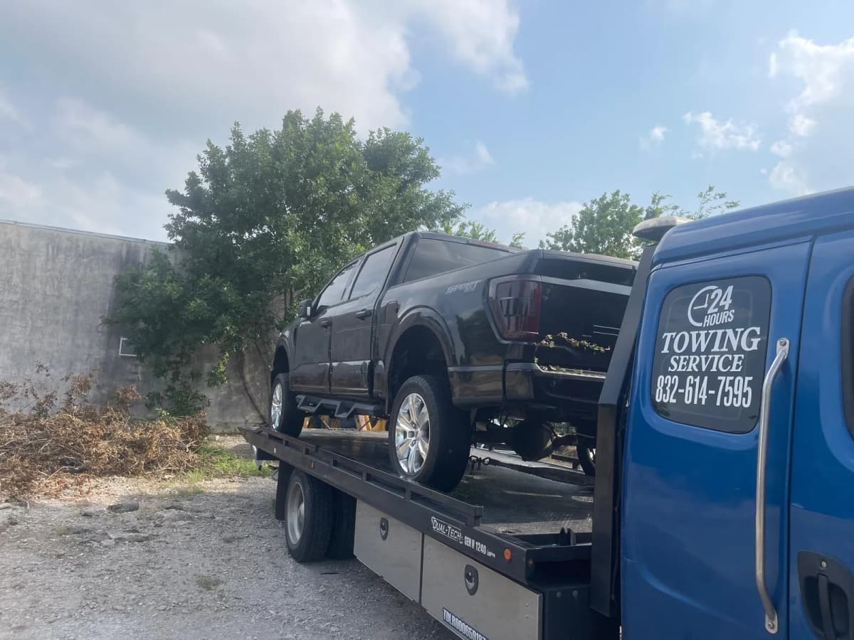 Ford F-250 Towing - Houston TX Dark Ford F-250 pickup truck on flatbed tow truck in Houston TX