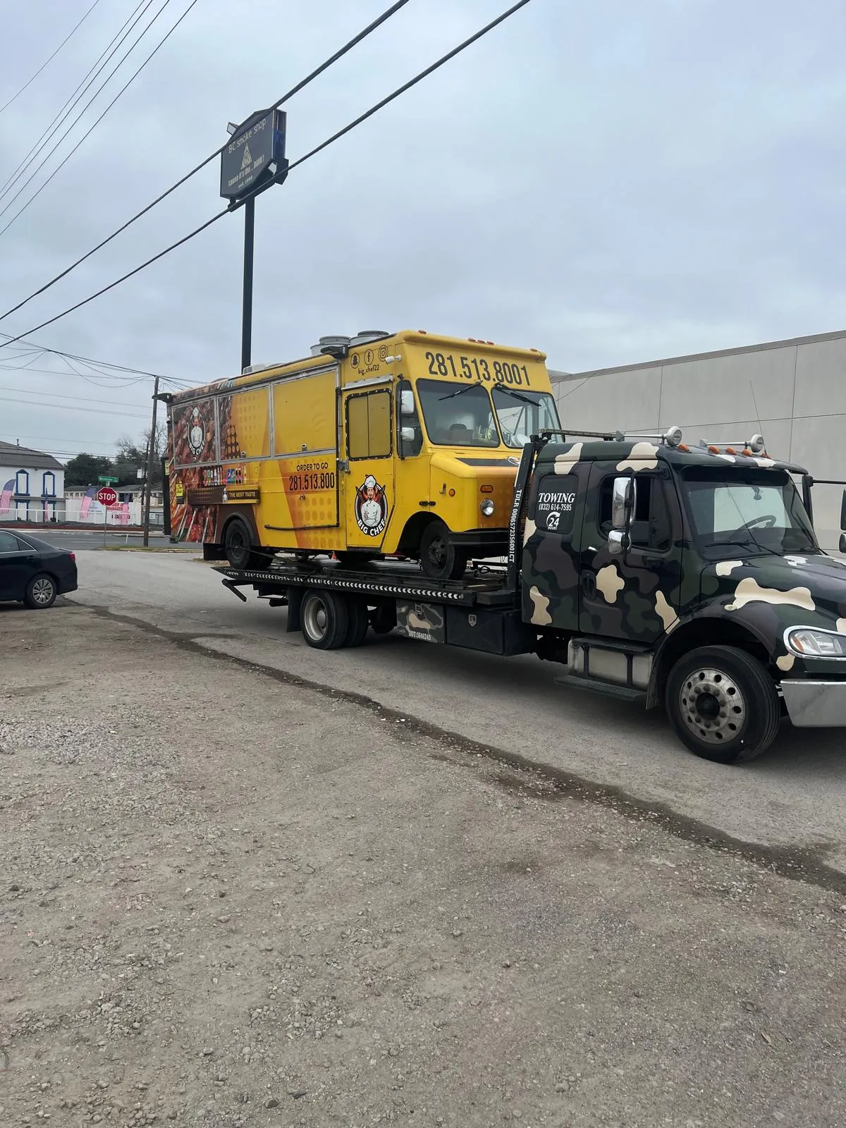 Yellow food truck being towed by flatbed in Houston TX