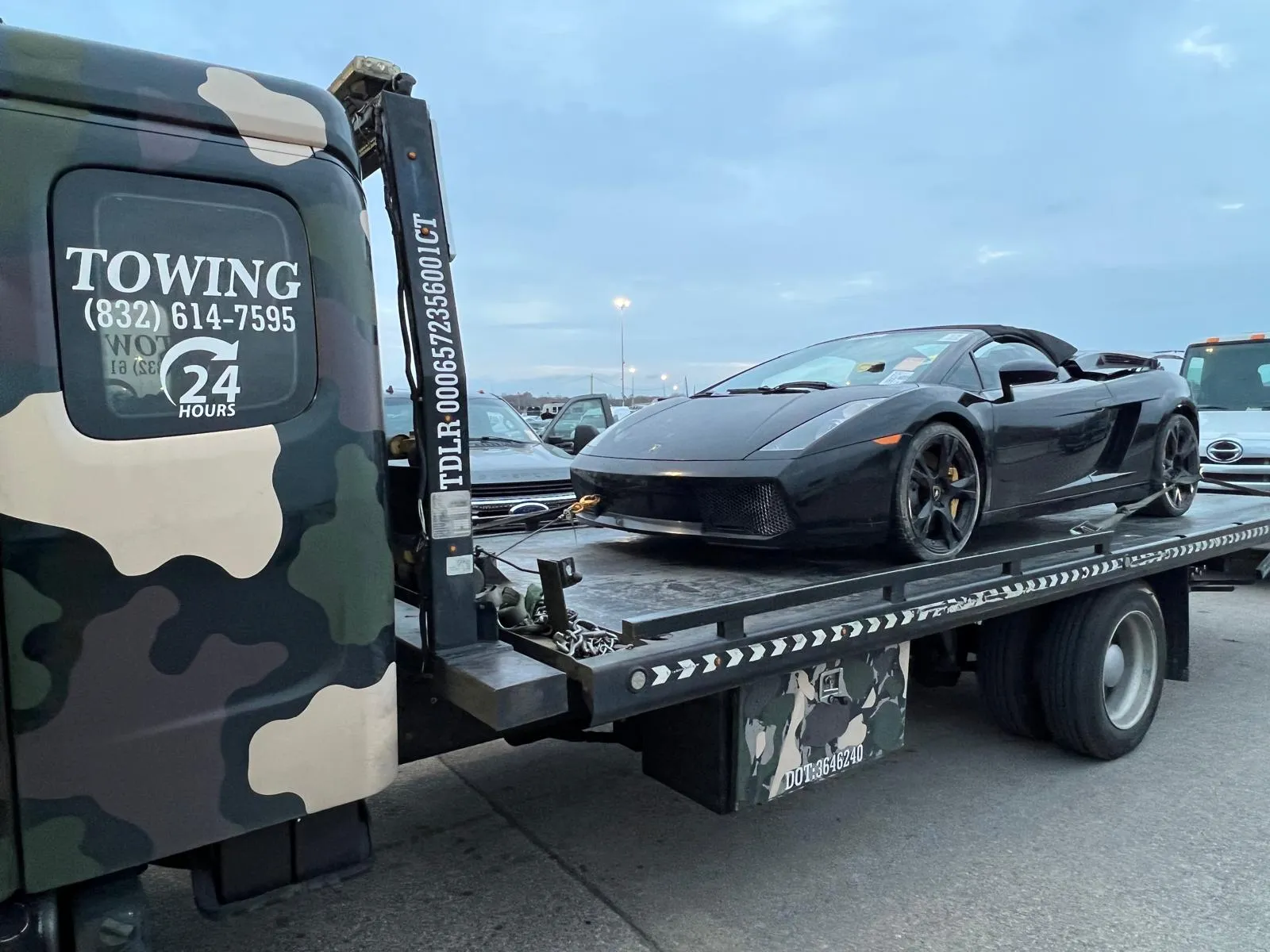 Black Lamborghini Gallardo on flatbed tow truck in Houston TX