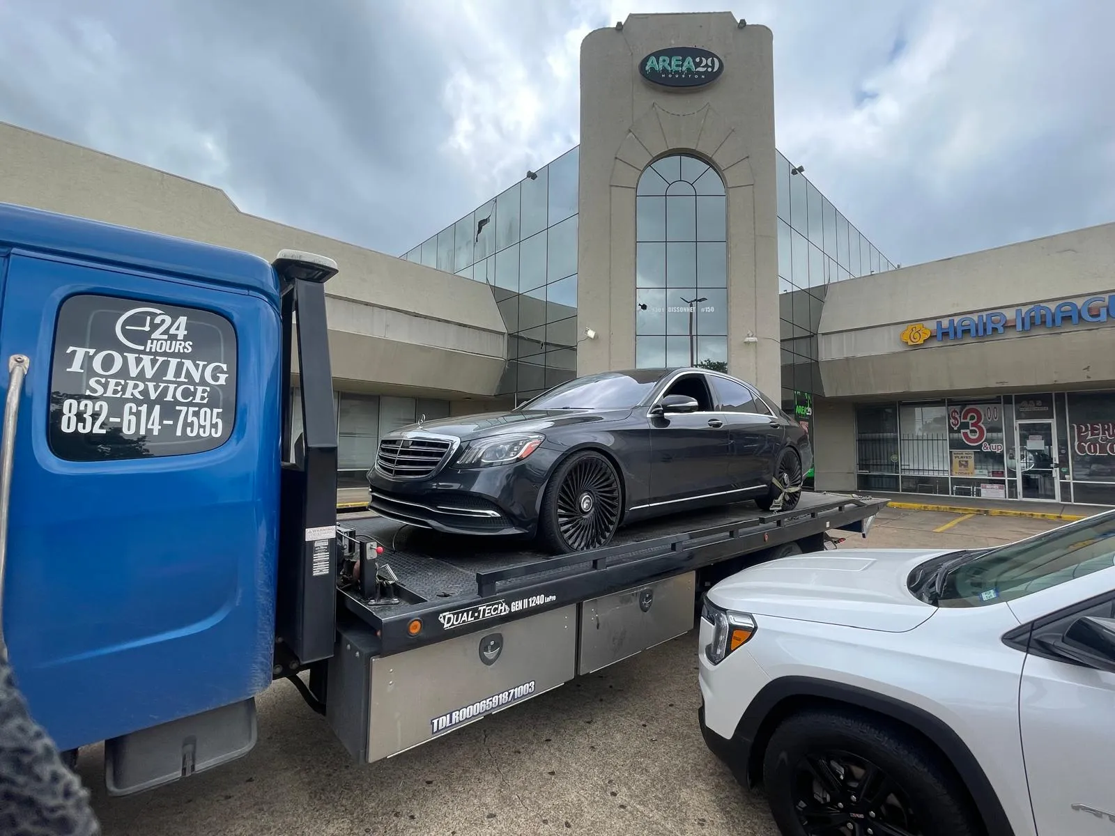 Black Mercedes-Benz S-Class on flatbed tow truck near Harwin Drive Houston TX