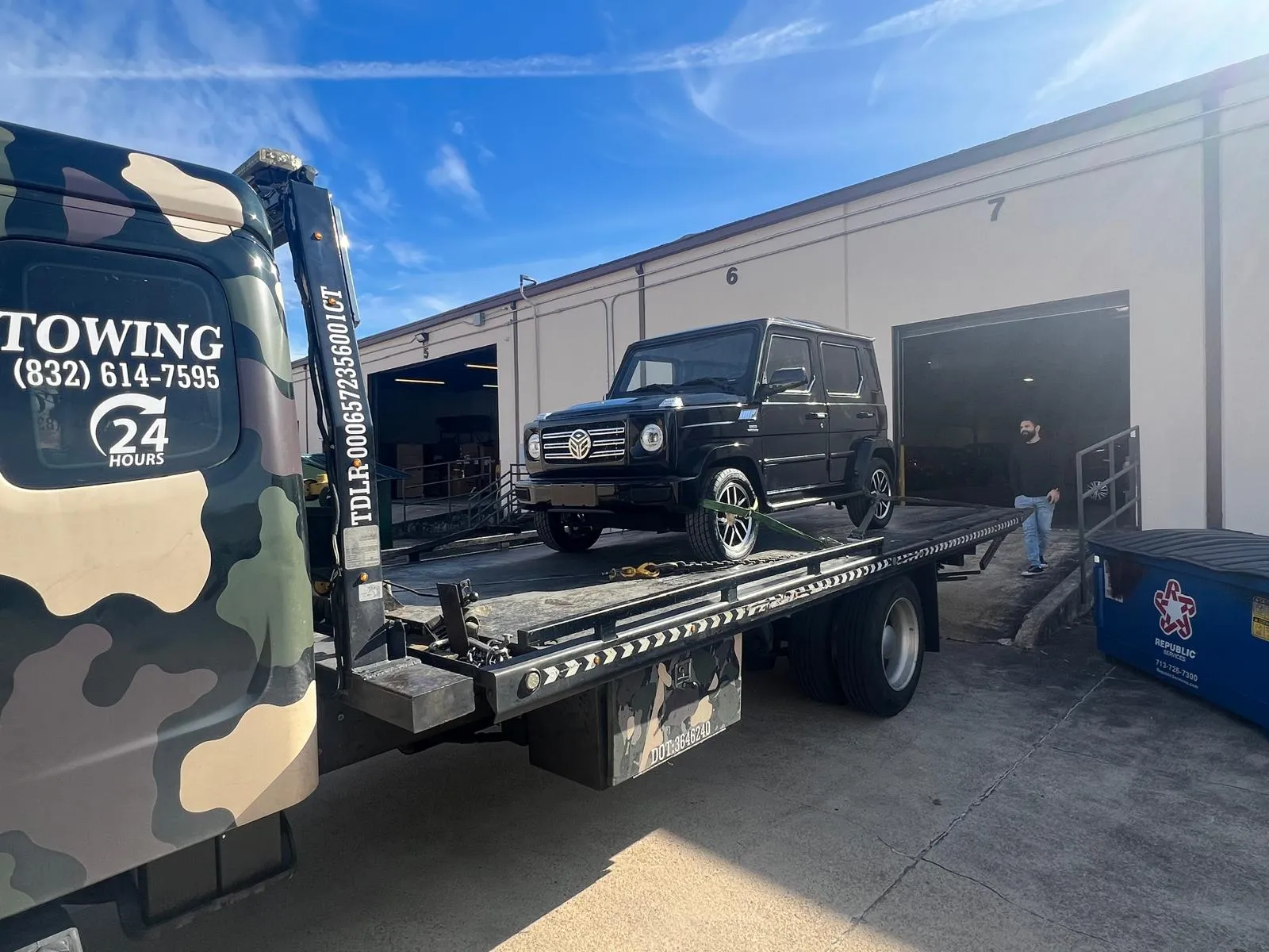 Black Mercedes G-Wagon on flatbed tow truck at Houston TX service shop