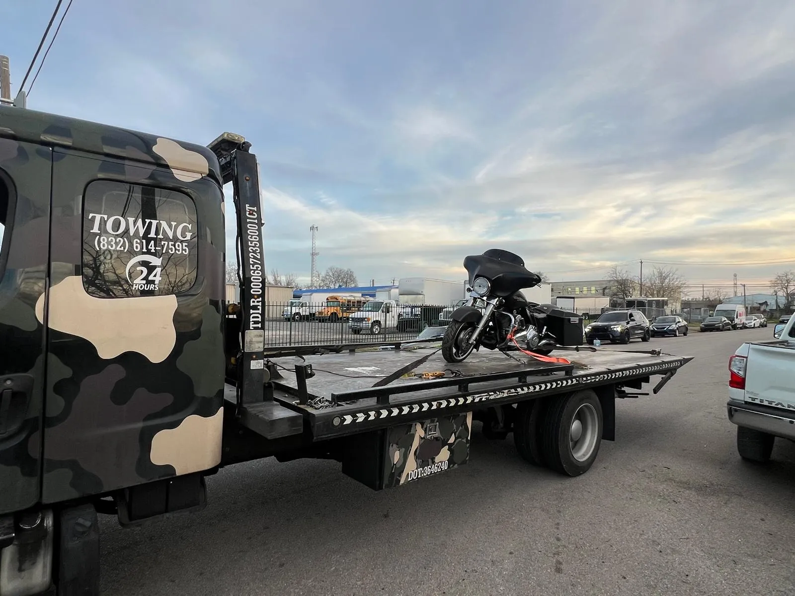 Black Harley-Davidson touring motorcycle on flatbed tow truck in Houston TX