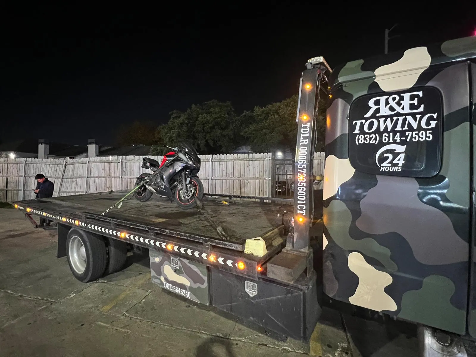 Sport motorcycle on flatbed tow truck at night in Houston TX