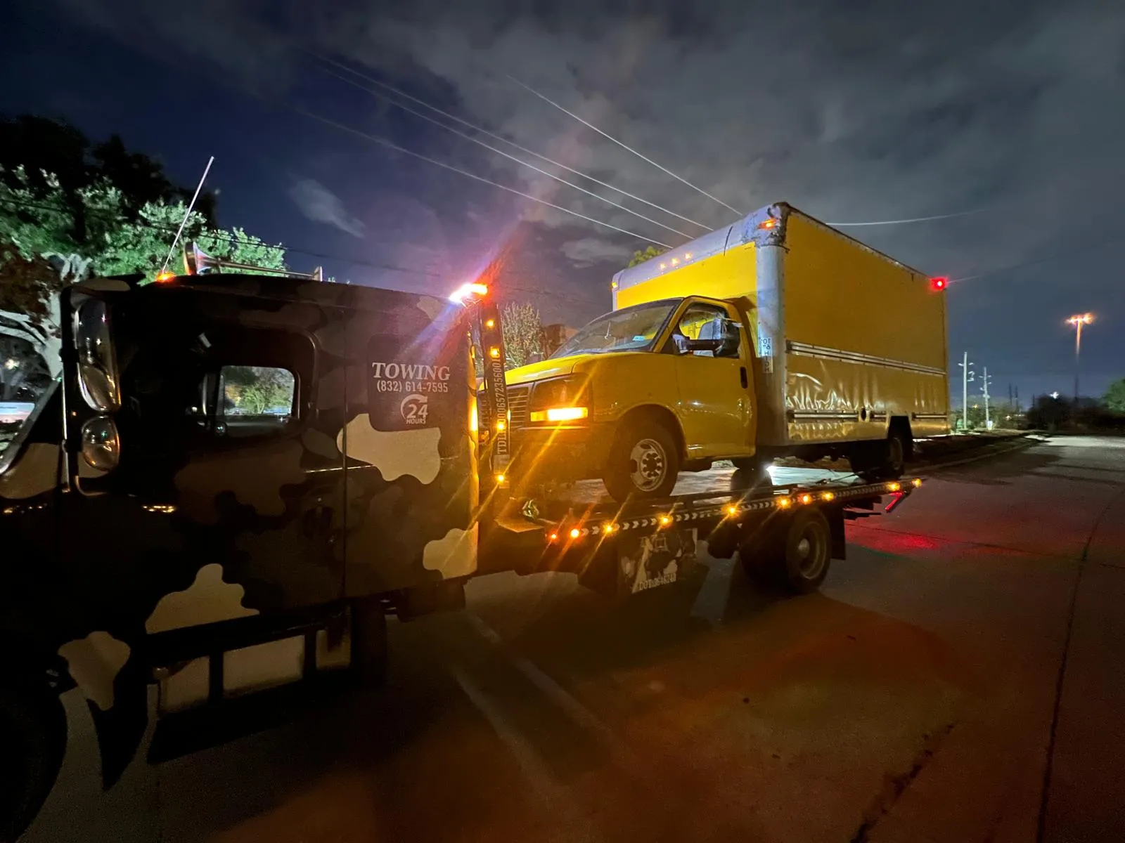 Yellow box truck being towed at night in Houston TX