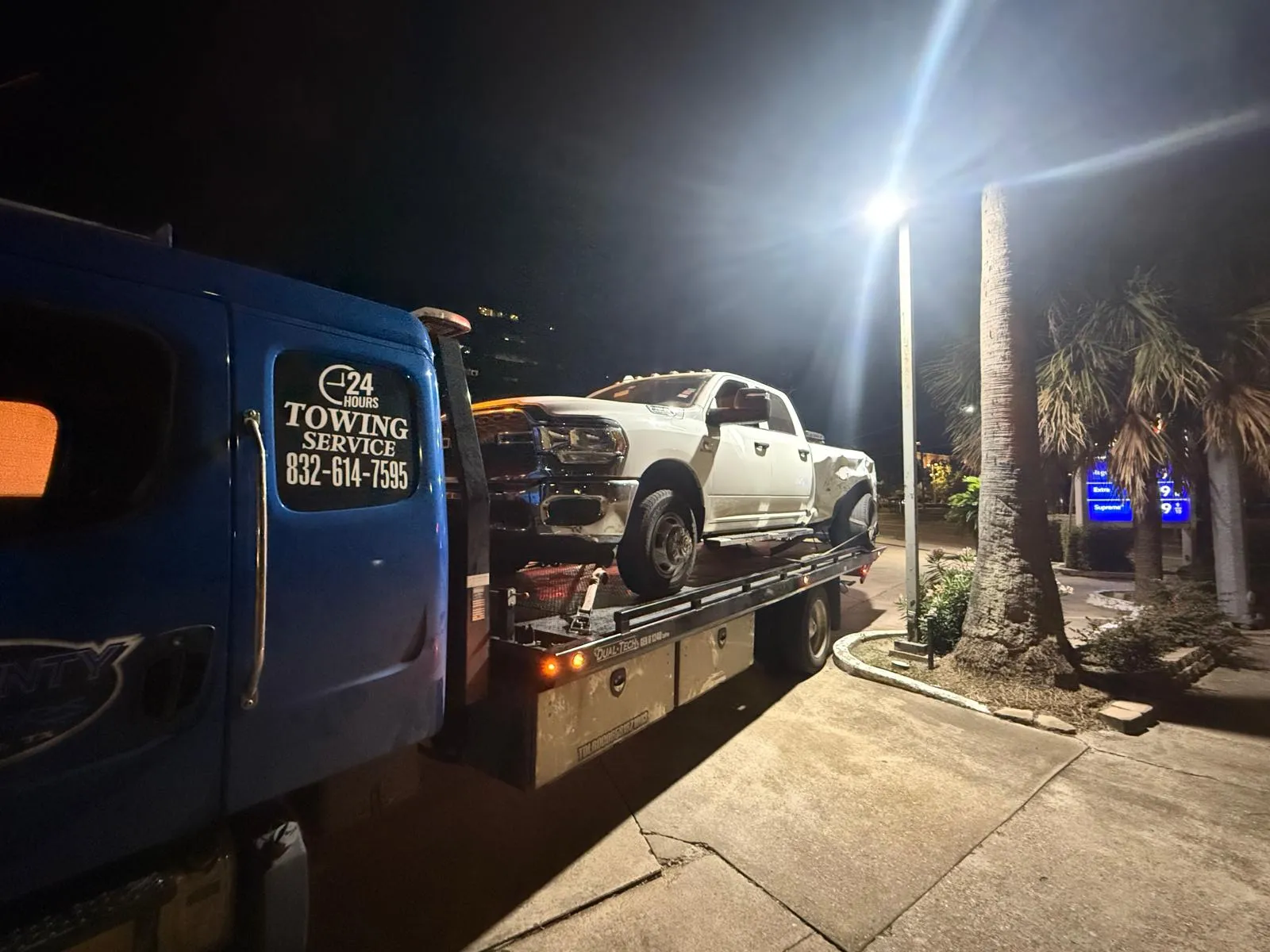 24/7 night emergency towing service - white RAM truck on flatbed in Houston TX