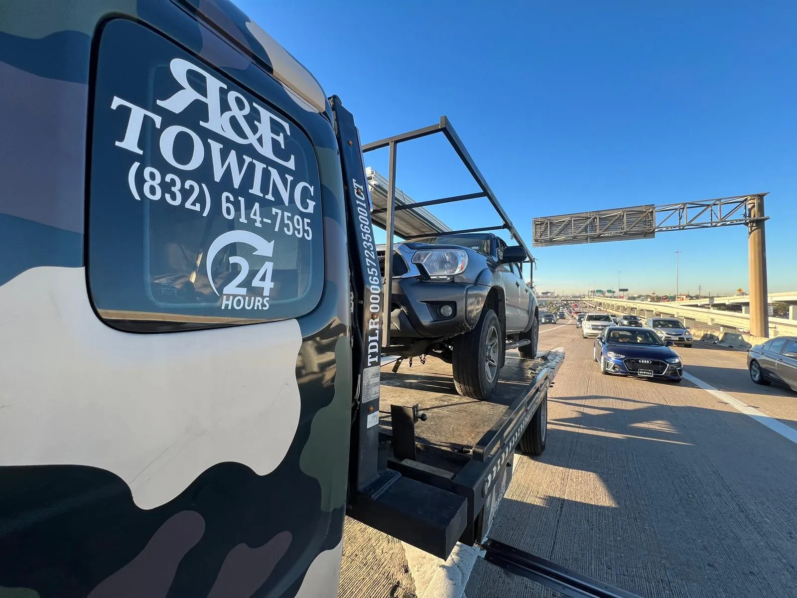 Off-road vehicle on flatbed tow truck on highway near Houston TX